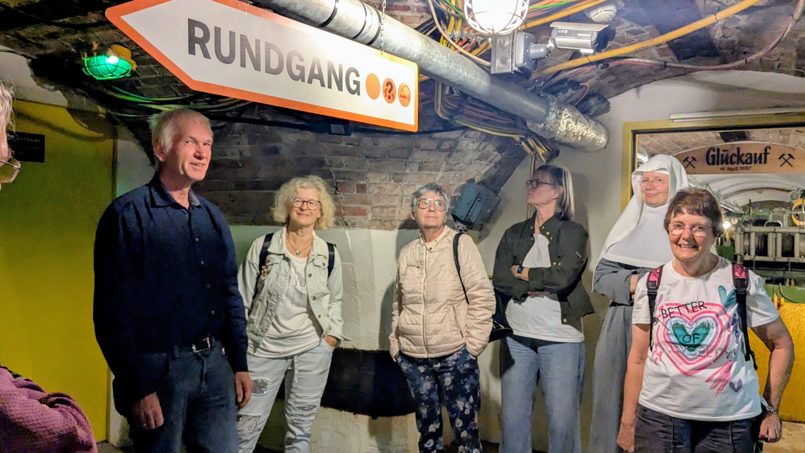 Besuchergruppe mit Führer bei einem Rundgang durch ein unterirdisches Bergwerksmuseum.